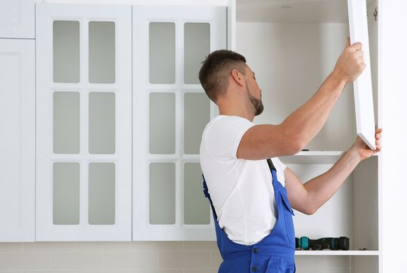 Worker opening a kitchen cabinet during refacing