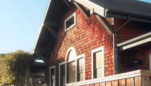 House with dark red wooden shingle siding