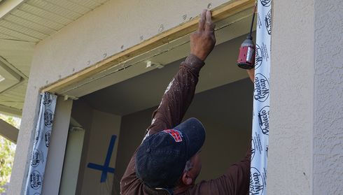 Installs a door frame using a power drill