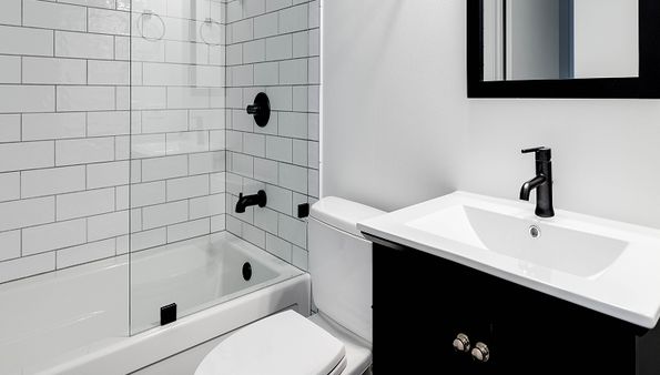 Modern bathroom with white subway tiles, glass shower, black fixtures