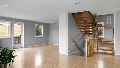 Empty room with light hardwood flooring and staircase