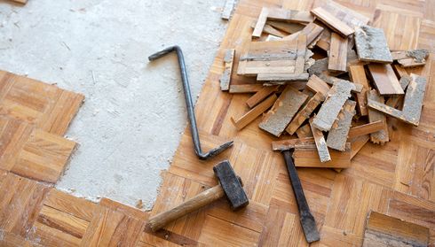 Parquet removal tools and wood pieces on floor